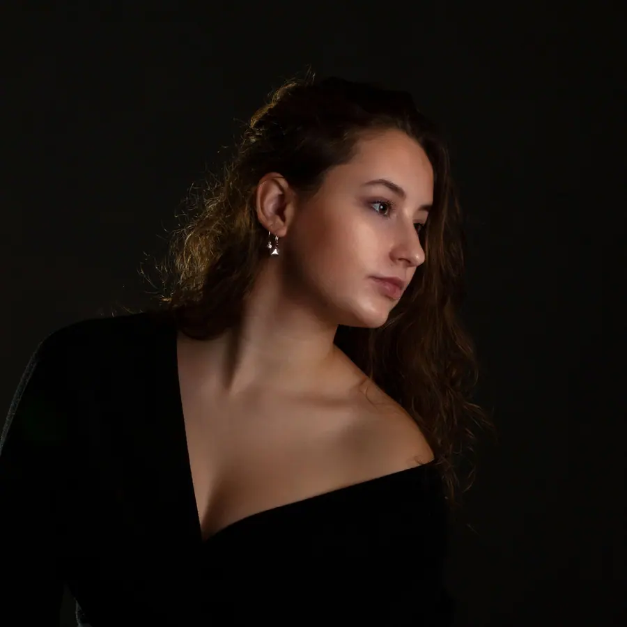Jonge vrouw met krullend haar op een zwarte achtergrond
