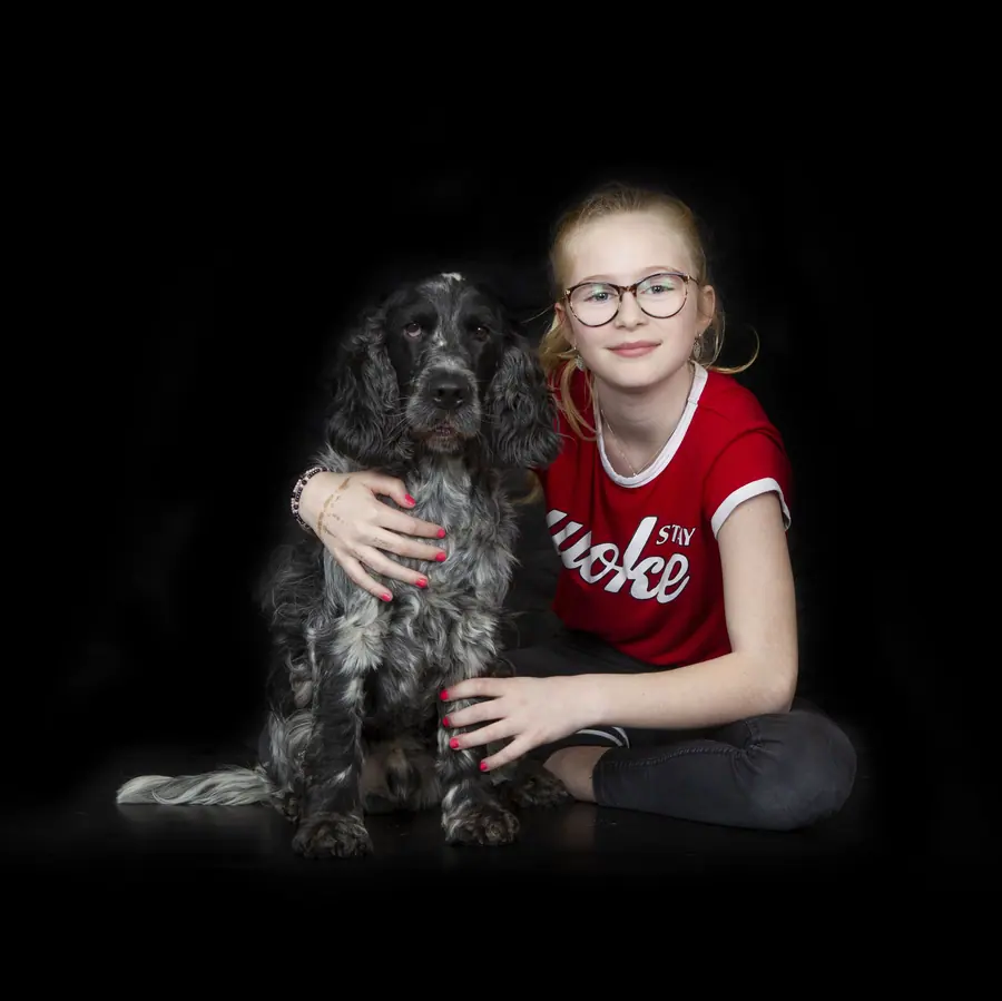 Meisje met bril naast een hond
